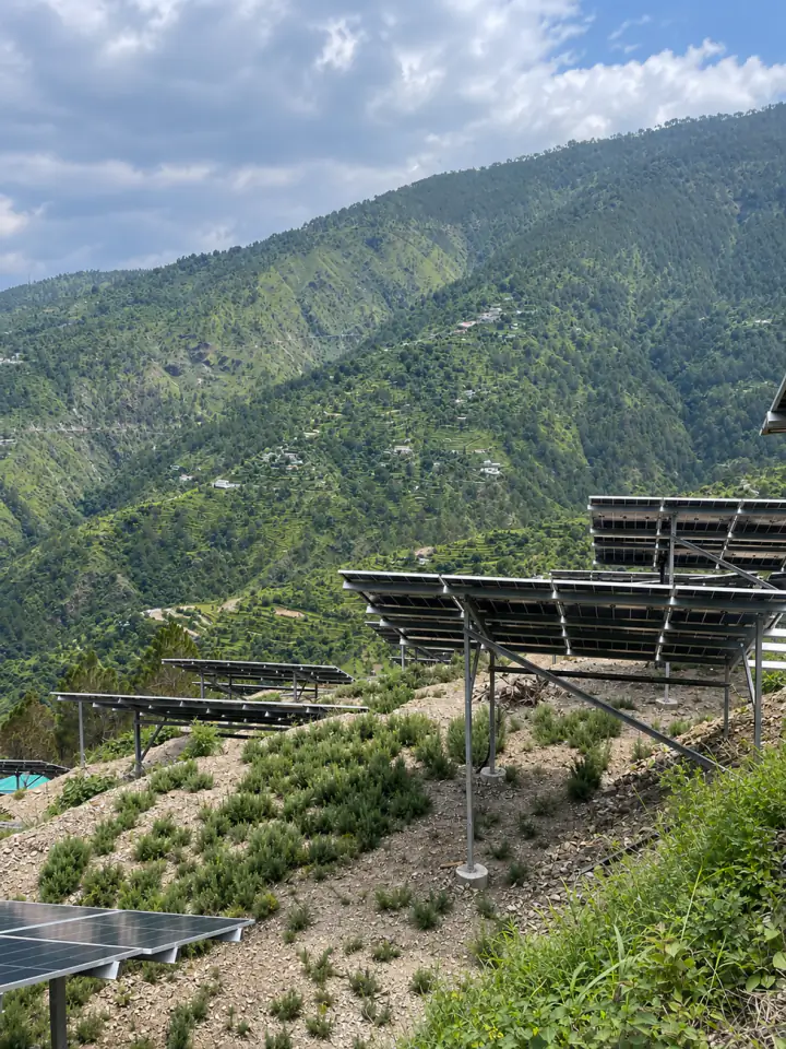 Raised solar tables and young rosemary rows on the terraced slope of the pilot site